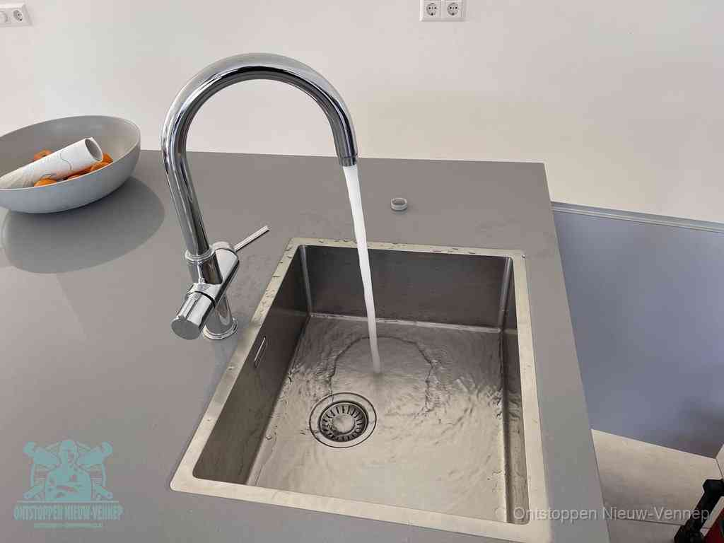 Een vrij doorstromende rvs spoelbak waar het water moeiteloos wegloopt, het resultaat van slim onderhoud dat geld bespaart in Nieuw-Vennep