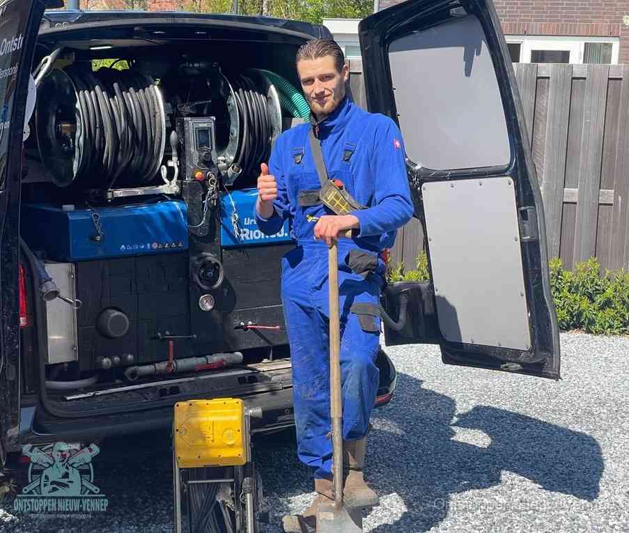 Een monteur bij de werkbus met grote hogedruk-slanghaspels, apparatuur voor hardnekkige afvoerverstoppingen in Nieuw-Vennep