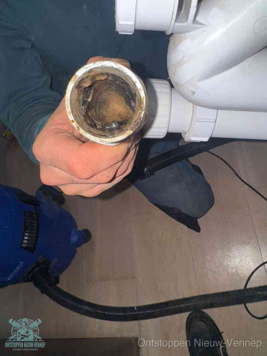 Een losgekoppelde afvoerbuis die van binnen volledig is dichtgeslibd met vet en aanslag, de meest voorkomende oorzaak van een verstopte gootsteen in Nieuw-Vennep