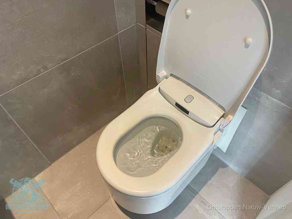 Een toiletpot vol troebel water met drijvend papier en restanten, de meest voorkomende oorzaak van een verstopte wc in Nieuw-Vennep