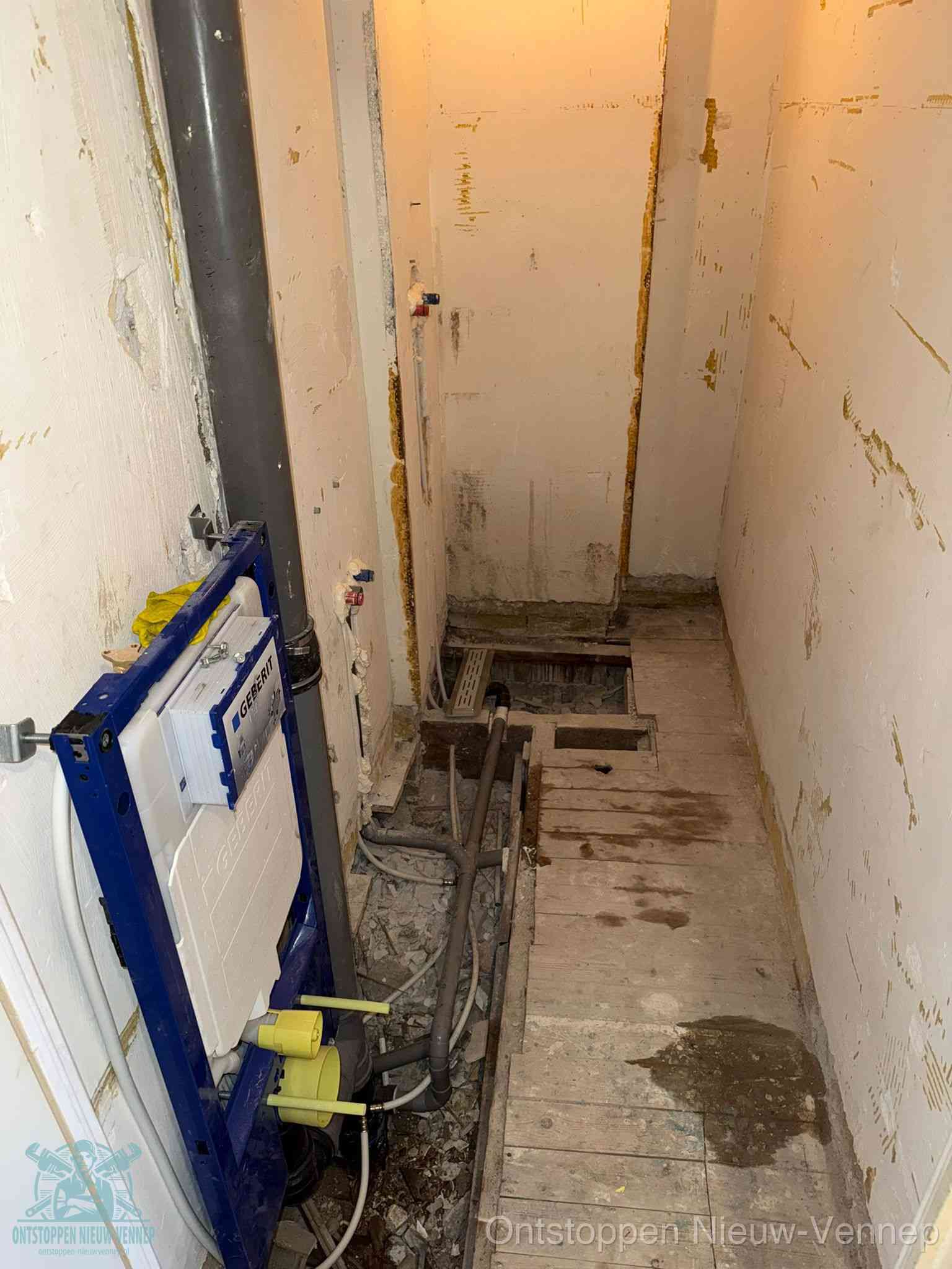 Een opgebroken toiletruimte tijdens renovatie met een Geberit inbouwreservoir en blootliggende oude afvoerleidingen, typisch voor oudere woningen in Nieuw-Vennep